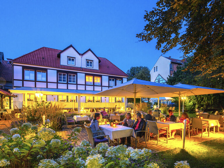 Beleuchtete Gartenterasse im Braunschweiger Hof, umgeben von viel Grün.