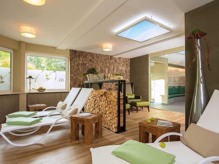 Ein gemütlich eingerichteter Ruheraum im Braunschweiger Hof mit mehreren komfortablen Liegen und Sesseln.